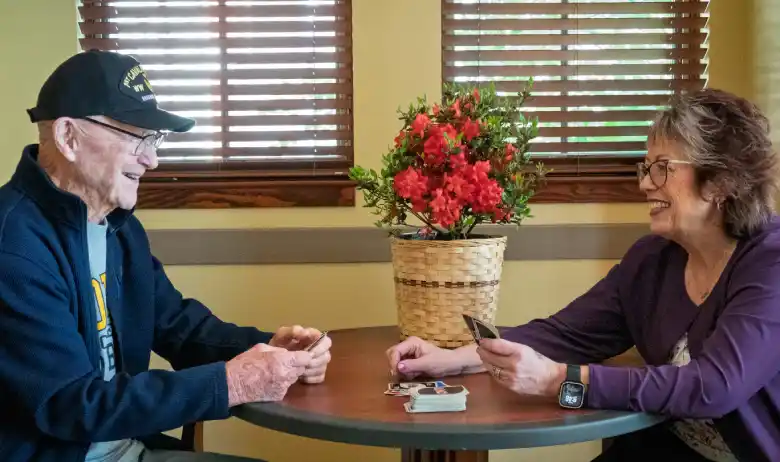 Hospice patient playing cards with a caregiver